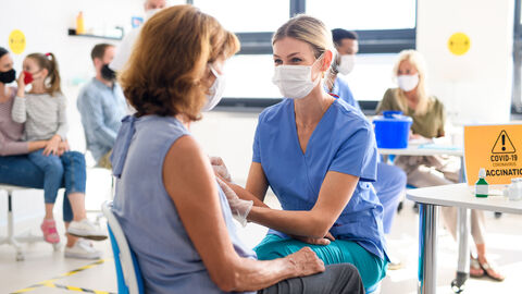 Junge Frau impft andere Frau