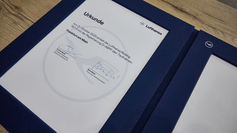 Eine unterschriebene Urkunde, die auf einem Holztisch liegt.