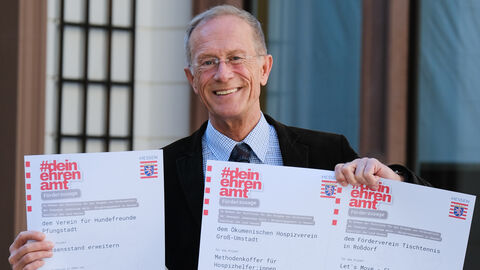 Staatsminister Axel Wintermeyer hält drei Förderbescheide in der Hand, die er an die jeweiligen Vereine für ihr Engagement übergibt. 