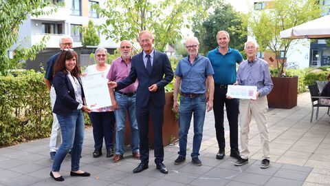 Hessens Chef der Staatskanzlei, Axel Wintermeyer, mit der AWO-Quartiersmanagerin Bianka Pötter, Michael Aufenanger und ehrenamtlichen Di@-Lotsen bei der Urkundenübergabe in Baunatal.